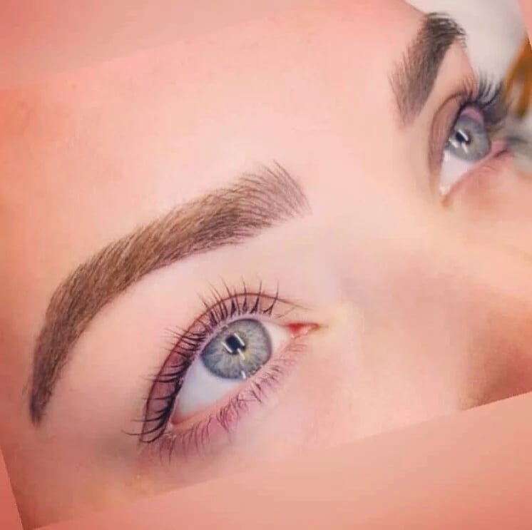 Woman's face showing blue eyes with defined eyebrows and pink-toned eyeshadow — lash and brow result